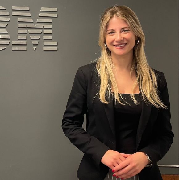 Employee standing in front of an IBM sign